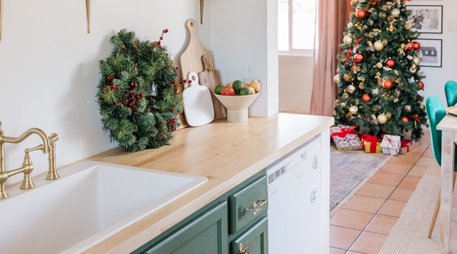 Kitchen counter with a lit up Christmas tree in the background.